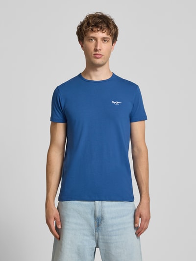 Männermodel trägt Slim Fit T-Shirt aus Baumwoll-Mix Modell 'ORIGINAL BASIC 3N' von Pepe Jeans in Unifarbe mit Label Print, Ganzkörperansicht von vorne.