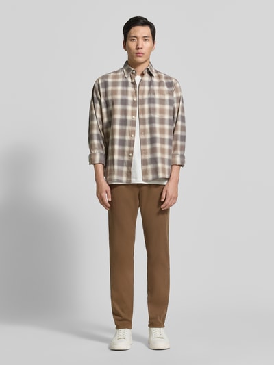 Männermodel trägt Regular Fit Hose mit Eingrifftaschen Modell 'Lyon' von Pierre Cardin, Baumwoll-Elasthan-Mix, Ganzkörperansicht von vorne, Herren, braune Hose und cremefarbene Sneaker, neutrale Farben, glatte Textur, Bundweite 41 cm, Innenbeinlänge 80 cm, Größe 32/32.