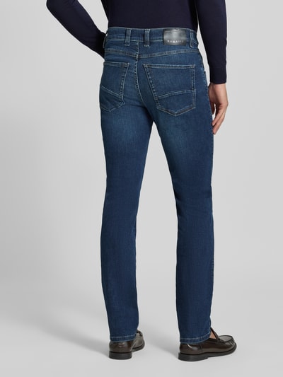 Mężczyzna nosi Regular Fit Jeans im 5-Pocket-Design od bugatti, mieszanka bawełny, zapięcie na guzik i zamek błyskawiczny, 5 kieszeni, szerokość w rozmiarze 32/32: 43 cm, długość wewnętrzna nogawki w rozmiarze 32/32: 82 cm, ciemnoniebieski denim, widoczne przeszycia, widok całej sylwetki z tyłu.
