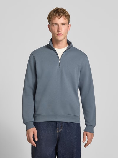 Männermodel trägt Regular Fit Sweatshirt mit Baumwoll-Anteil Modell 'Bradley' von JACK & JONES, blau, Troyer-Kragen, Ganzkörperansicht von vorne.