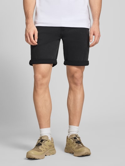 Männermodel trägt Slim Fit Jeansshorts aus Baumwoll-Mix Modell 'CK ESSENTIAL BLACK' von Calvin Klein Jeans, schwarze Denim-Optik, Ganzkörperansicht von vorne.
