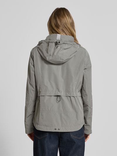 Vrouwenmodel draagt Jacke mit Kapuze und Eingrifftaschen van Gil Bret in grijs, regular fit, knoopsluiting, ritszakken, ruglengte 67 cm, schouderbreedte 40 cm, borstwijdte 46 cm, mouwlengte 64 cm, weather protection, ganzkörperaanzicht achteraan.