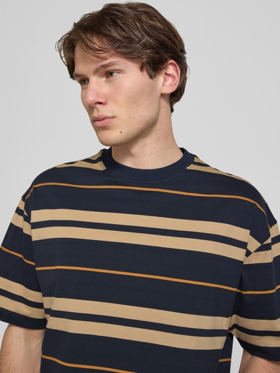 Männermodel trägt oversized shirt aus reiner katoen model 'NIVARSI' van HUGO Blue in donkerblauw met beige strepen, Nahaufnahme Oberkörper