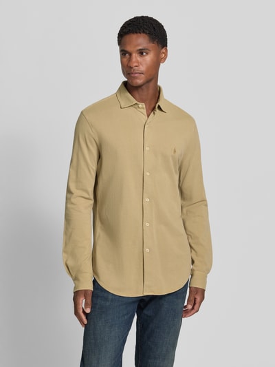 Männermodel trägt Slim Fit Freizeithemd aus reiner Baumwolle von Polo Ralph Lauren in Beige, glatte Textur, Ganzkörperansicht von vorne.