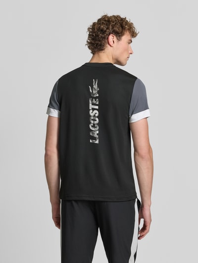 Männermodel trägt Regular Fit Sport-T-Shirt im Colorblock-Design von Lacoste, Herren Sport-T-Shirt von Lacoste Sport, Ganzkörperansicht Rückansicht.