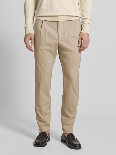 Männermodel trägt Hose aus Schurwolle-Mix mit französischen Eingrifftaschen von CRUNA in Beige mit Tapered Fit, Nahaufnahme Vorderansicht.