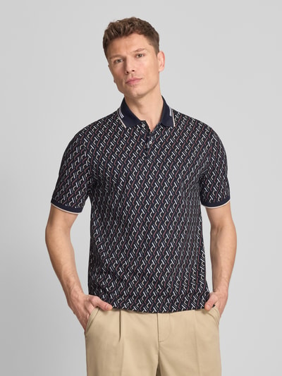 Männermodel trägt Slim Fit Poloshirt im Allover-Look von bugatti aus Baumwoll-Mix mit Stretch-Anteil, Knopfleiste, Ganzkörperansicht von vorne. Rückenlänge bei Größe M: 71 cm.