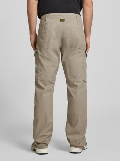 Männermodel trägt Straight Fit Cargohose mit Gesäßtaschen von G-Star Raw, beige, reine Baumwolle, lockerer Schnitt, Ganzkörperansicht Rückansicht.