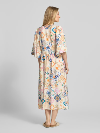 Frauenmodel trägt Tunikakleid aus Viskose-Mix mit Leinen-Viskose-Anteil, A-Linie, Midikleid, Modell 'LANCIE' von ICHI, Allover-Look, bunte Muster, V-Ausschnitt, Knopfleiste, Rückenlänge bei Größe 36: 103 cm, Brustweite bei Größe 36: 34 cm, Ärmellänge bei Größe 36: 39 cm, Ganzkörperansicht Rückansicht.