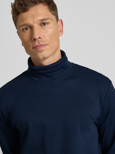 Męski model nosi Regular Fit Rollkragenpullover aus Baumwoll-Mix od Tom Tailor, granatowy, gładki, logo, zbliżenie na górną część ciała.
