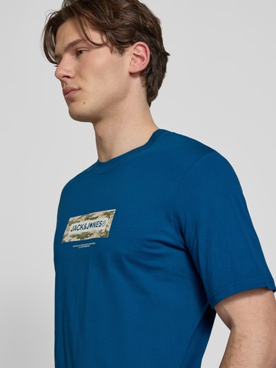 Männermodel trägt T-Shirt mit Logo und Rundhalsausschnitt von Jack & Jones in Blau, Reine Baumwolle, Regular-Fit, Nahaufnahme Oberkörper.