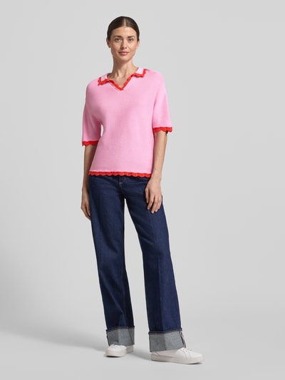 Kobiece modelka nosi Strickshirt mit Polokragen und V-Ausschnitt von Christian Berg Woman z bawełny, krój regular fit, paski w kontrastowym kolorze, falisty brzeg, różowy z czerwonym akcentem, długość tyłu w rozmiarze S: 57 cm, długość rękawów w rozmiarze S: 25 cm, pełny widok z przodu