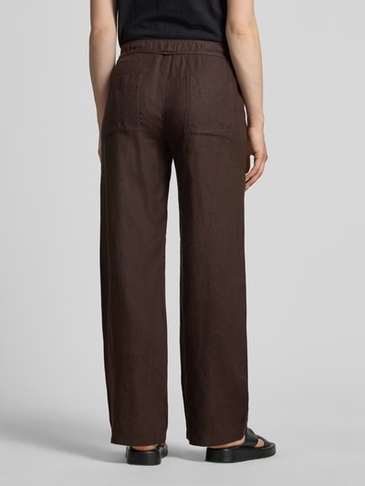 Frauenmodel trägt Leinenhose mit Bindegürtel Modell 'Chiara' von MAC, Reine Leinen, Wide-Fit, braun, Struktur sichtbar, Ganzkörperansicht Rückansicht.