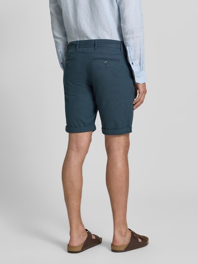 Männermodel trägt Slim Fit Chinoshorts aus Baumwoll-Mix Modell 'LUTON' von SELECTED HOMME in Unifarben mit feiner Webstruktur, Ganzkörperansicht Rückansicht.