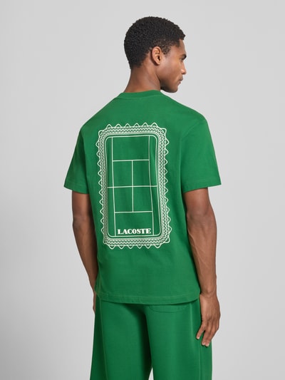 Männermodel trägt grünes Regular Fit T-Shirt aus reiner Baumwolle Modell 'CN Tenniscourt Backprint' von Lacoste, Herren T-Shirt, Ganzkörperansicht Rückansicht