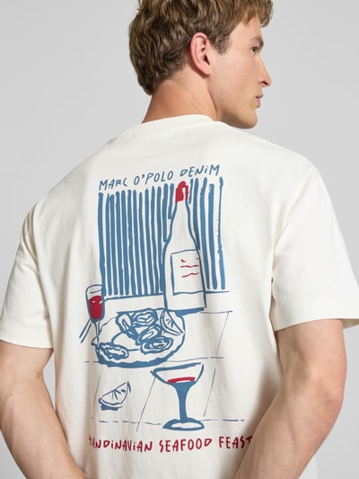 Männermodel trägt Relaxed Fit T-Shirt aus reiner Baumwolle von Marc O'Polo Denim, Optik: Unifarben, Motiv-Print, Ganzkörperansicht Rückansicht.