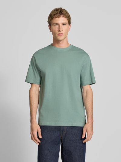 Männermodel trägt Relaxed Fit T-Shirt aus reiner Baumwolle Modell 'FRED LIFE' von Only & Sons, Optik: Unifarben, Ganzkörperansicht von vorne.