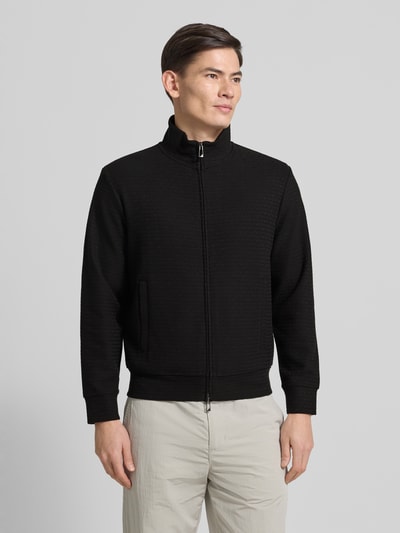Männermodel trägt Sweatjacke mit Stehkragen von Emporio Armani, Schwarz, Baumwoll-Lyocell-Mix mit Stretch-Anteil, lockerer Schnitt, Reißverschluss, Eingrifftaschen, gerippte Abschlüsse, Rückenlänge 64 cm, Ärmellänge 60 cm, Ganzkörperansicht von vorne.