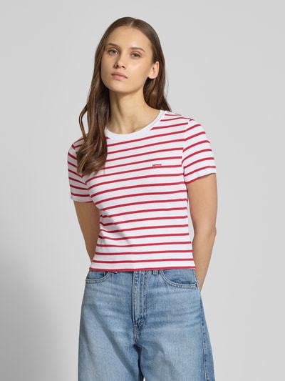 Frauenmodel trägt T-Shirt in Ripp-Optik mit Label-Stitching von Levi's®, rot-weiß gestreift, Slim Fit, Baumwoll-Mix, Ganzkörperansicht von vorne.