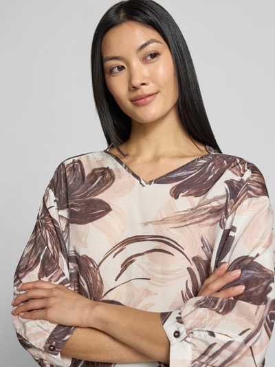 Frauenmodel trägt Relaxed Fit Bluse aus Viskose-Mix mit floralem Allover-Print von MORE & MORE, V-Ausschnitt, 3/4-Arm, Nahaufnahme Oberkörper.