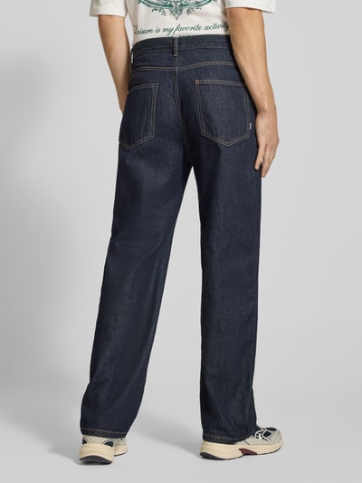 Mannenmodel draagt Baggy Fit Jeans met steekzakken van REVIEW, donkerblauw katoen, rechte loose fit, detail zichtbare stiksels, fullbody achteraanzicht.