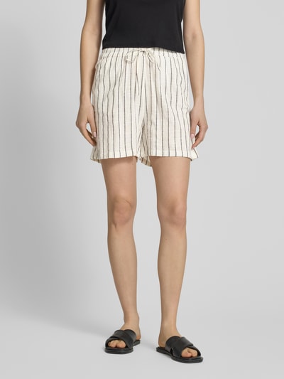 Frauenmodel trägt Regular Fit Shorts aus reiner Baumwolle Modell 'TIZIANA' von Only mit gestreiftem Allover-Muster, 5-Pocket-Design, Tunnelzugbund in Beige und Schwarz, Ganzkörperansicht von vorne.
