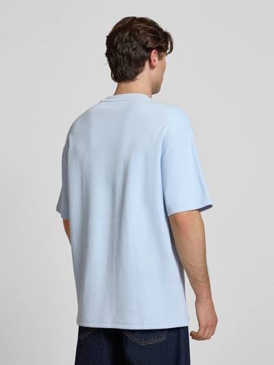 Männermodel trägt Relaxed Fit T-Shirt aus Baumwoll-Mix Modell 'NUWAFFLE' von HUGO in Blau, Optik: Unifarben, Struktur, Ganzkörperansicht Rückansicht.