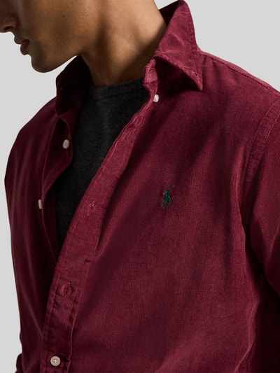 Männermodel trägt Custom Fit Freizeithemd aus reiner Baumwolle von Polo Ralph Lauren in Dunkelrot mit strukturiertem Stoff, Nahaufnahme Oberkörper.