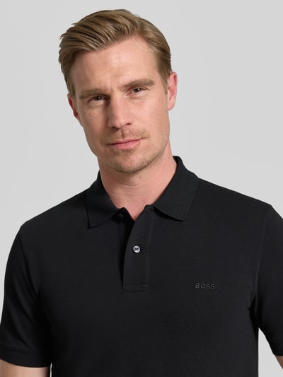 Männermodel trägt Regular Fit Poloshirt aus reiner Baumwolle Modell 'PALLAS' von BOSS, Optik: Unifarben, Nahaufnahme Oberkörper.