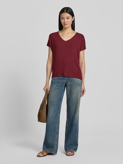 Frauenmodel trägt Relaxed Fit T-Shirt aus Viskose-Mix von s.Oliver RED LABEL in Dunkelrot, kombiniert mit blauen Jeans, Ganzkörperansicht von vorne.