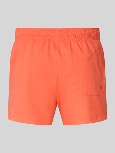 Produktfoto, Badehose mit Seitentaschen und Klettverschlusstasche hinten von PUMA in Orange, elastischer Bund, glatte Oberfläche, Rückansicht