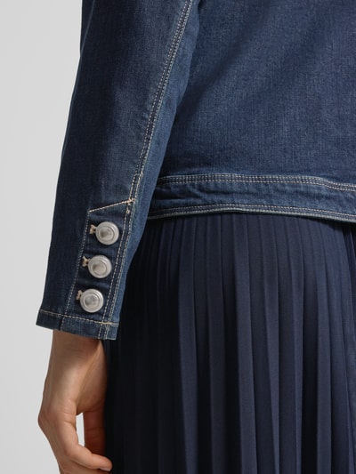 Frauenmodel trägt Regular Fit Jacke mit Lyocell-Anteil in Denim-Optik von Betty Barclay, dunkelblauer Lyocell-Baumwolle-Mix, aufgesetzteTaschen, Rundhalsausschnitt, durchgängige Knopfleiste, Nahaufnahme Unterarm.