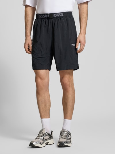 Männermodel trägt Shorts mit Gürtel Modell 'Sequoia Grove™' von Columbia in Schwarz, lockerer Schnitt, Ganzkörperansicht von vorne.