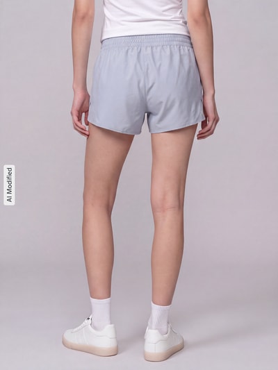 Frauenmodel trägt Regular Fit Sportshorts mit elastischem Bund von Under Armour in hellem Blau, glatte Textur, Ganzkörperansicht Rückansicht, KI-modifiziertes Bild. Damen Sportshorts von Under Armour.