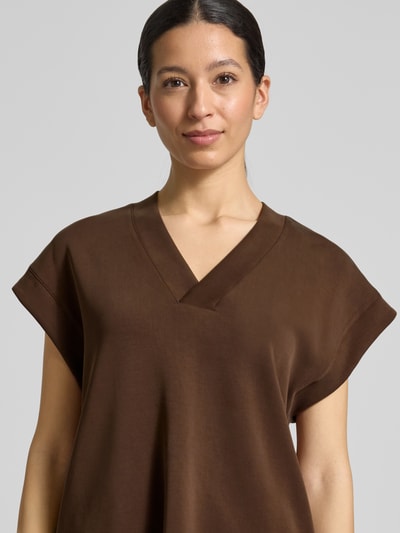 Frauenmodel trägt Relaxed Fit T-Shirt mit Lyocell-Anteil von Scotch & Soda in Braun, V-Ausschnitt, Kappärmel, elastischer Material-Mix, Nahaufnahme Oberkörper.