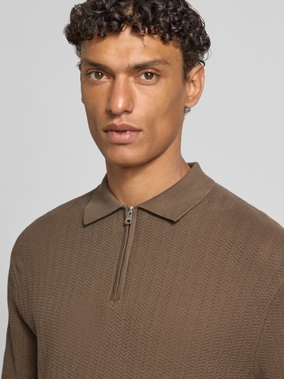 Männermodel trägt Regular Fit Poloshirt aus reiner Bio-Baumwolle Modell 'CRAN' von SELECTED HOMME in Strickoptik mit Struktur-Muster, Nahaufnahme Oberkörper.