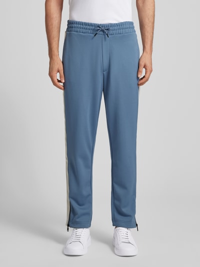 Männermodel trägt Relaxed Fit Jogginghose mit Galonstreifen Modell 'DOLOS' von HUGO, Optik: Unifarben, Sweat, Ganzkörperansicht von vorne.