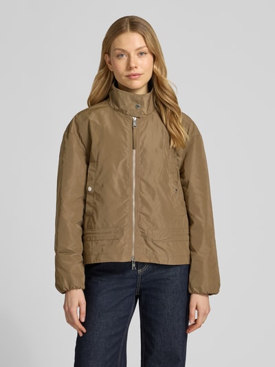 Vrouwenmodel draagt Jacke mit Zweiwege-Reißverschluss und Stehkragen van Fuchs Schmitt in bruin, rechte fit, gladde textuur, steekzakken met drukknoop, elastische mouwuiteinden, opstaande kraag, voorkant aanzicht halve lichaamsopname.