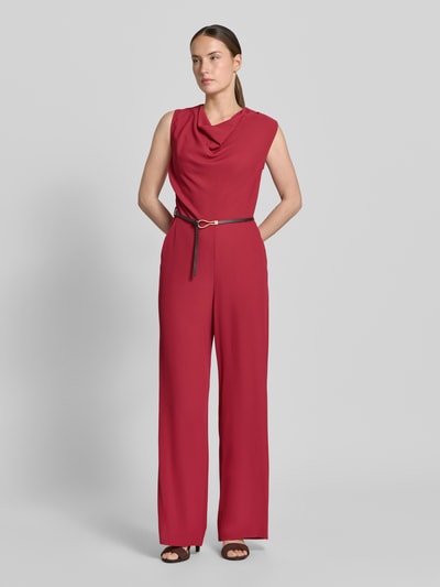 Vrouwenmodel draagt Jumpsuit met Wasserfall-Ausschnitt und Gürtel van Jake*s Collection in rood materiaalmix met stretch, regular fit, met riem, ganzlichaamsaanzicht van voren. Ruglengte maat 36: 152 cm, borstwijdte: 44 cm, totale lengte: 148 cm, binnenbeenlengte: 81 cm.