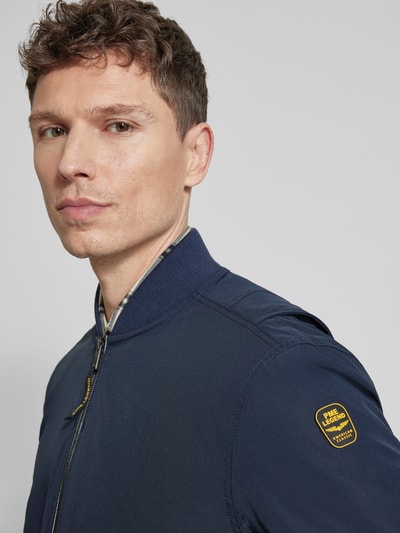 Männermodel trägt donkerblauwe Bomberjacke met ritssluiting en steekzakken van PME Legend, materiaalmix met stretch, regular fit, nahaufnahme oberkörper.