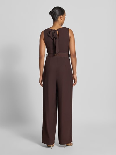 Frauenmodel trägt Jumpsuit mit Neckholder von Rinascimento in Dunkelbraun, Material-Mix mit Stretch, Stoffgürtel, Rückansicht, taillierte Passform. Ganzkörperansicht Rückansicht.