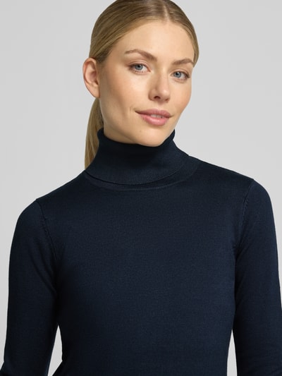 Kobiece modelka nosi Slim Fit sweter z dzianiny z mieszanki wiskozy, model 'IHLULS' od ICHI, kolor granatowy, golf, elastyczne wykończenia, długość tyłu 61 cm, długość rękawów 66 cm, zbliżenie na górę ciała.