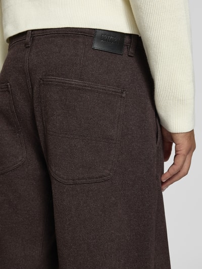 Männermodel trägt Straight Fit Stoffhose aus Baumwoll-Mix Modell 'GONAGO' von DRYKORN in Braun, Struktur sichtbar, Nahaufnahme Rückansicht.