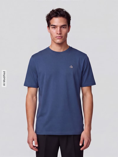 Männermodel trägt T-Shirt mit Label-Stitching und Rundhalsausschnitt von Scotch & Soda, reine Baumwolle, Regular Fit, Ganzkörperansicht von vorne, KI-modifiziertes Bild.