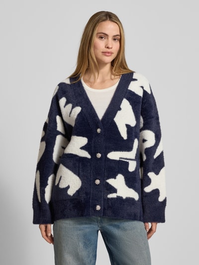 Frauenmodel trägt Comfort Fit Strickjacke mit Allover-Muster Modell 'JARDEN' von Essentiel Antwerp, V-Ausschnitt, Strick, Ganzkörperansicht von vorne.