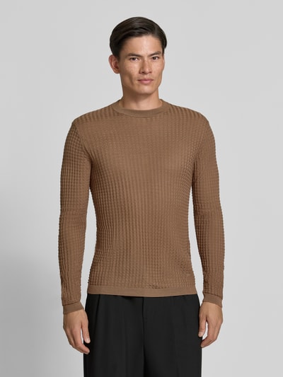 Männermodel trägt Strickpullover mit Struktur-Muster von Emporio Armani in Brauntönen, taillierter Schnitt, Ganzkörperansicht von vorne.