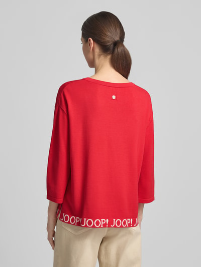 Frauenmodel trägt Strickpullover mit Label-Details und 3/4-Arm Modell 'Kussa' von JOOP! in Rot, Relaxed Fit, Rückenansicht