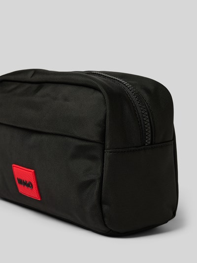 Produktfoto, Kulturbeutel mit Label Patch Modell 'ETHON 3.0' von HUGO, unifarben schwarz, grobe Webware, Reißverschluss, Hauptfach, Einschubfach, Label Applikation, Tragehenkel.