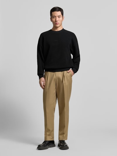 Männermodel trägt Regular Fit Sweatshirt aus reiner Baumwolle Modell 'DAFFLYN' von HUGO in Schwarz, Jacquard-Struktur, Ganzkörperansicht von vorne.