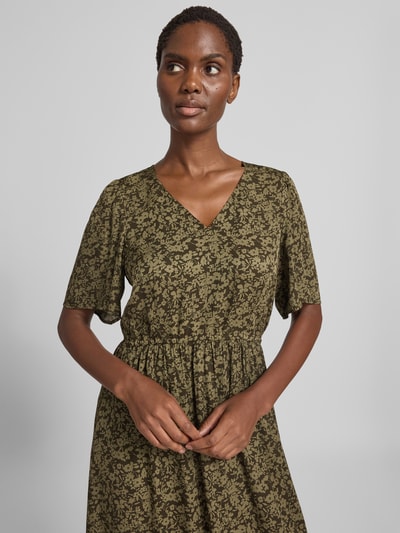Frauenmodel trägt Tailliertes Freizeitkleid aus reiner Viskose von Marc O'Polo in Olivgrün mit floralem Muster, Nahaufnahme Oberkörper, Damen Freizeitkleid von Marc O'Polo